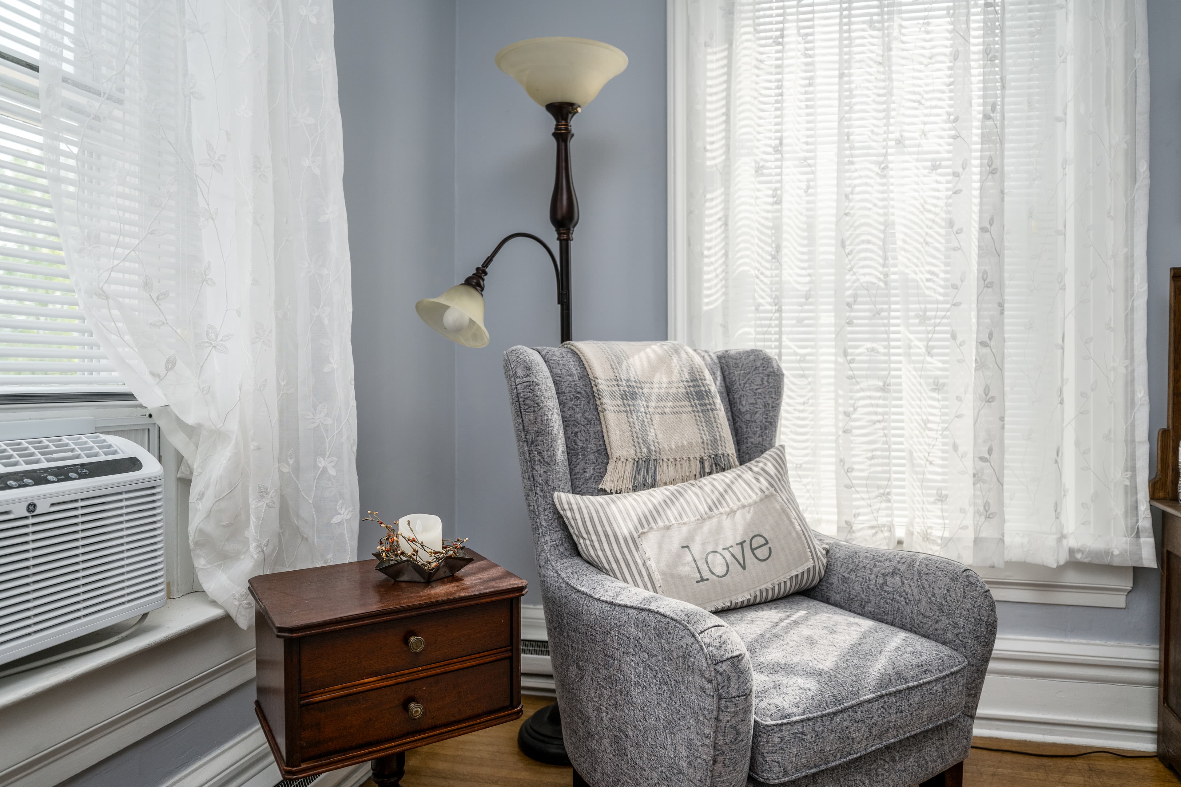 Armchair with tall reading lamp and wooden side table