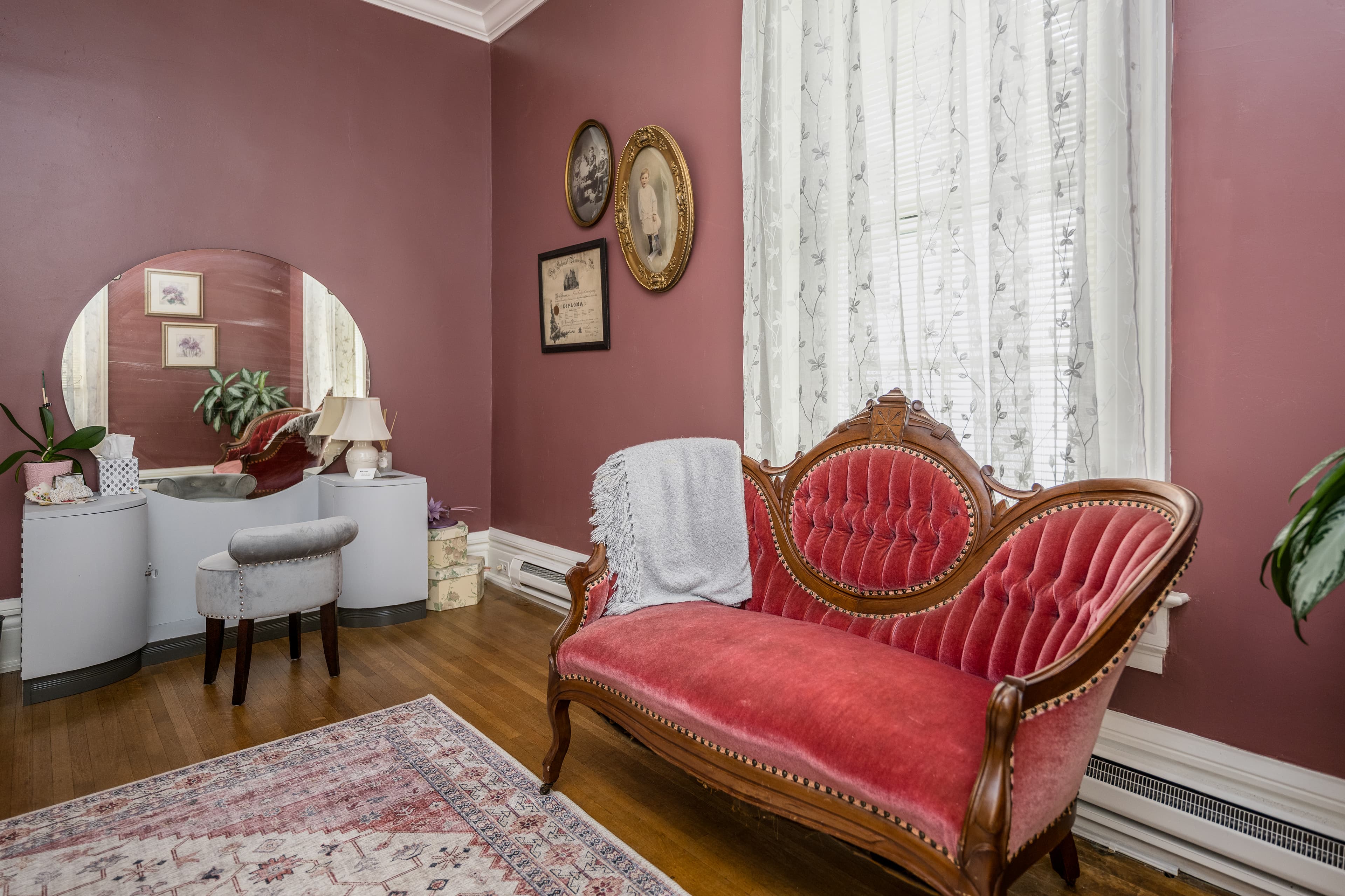 Room with dark pink walls and a luxurious pink antique sofa